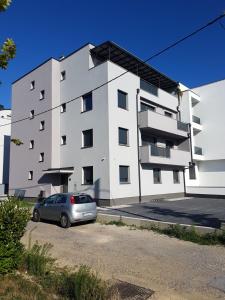 a white building with a car parked in front of it at Lake house in Zagreb