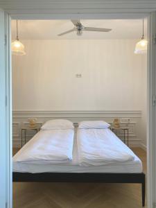 - une chambre avec 2 lits et 2 tables dans l'établissement Retro Apartment Iława, à Iława