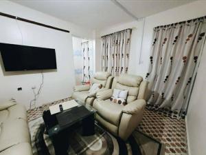 a living room with couches and a tv and a couch at Apartment in Rizal short stay only in Teresa