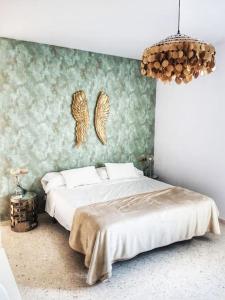a bedroom with a bed with a green wall at El Patio de San Bernardo in Seville