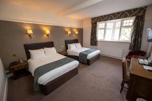 um quarto de hotel com duas camas e uma janela em Castle and Ball by Greene King Inns em Marlborough