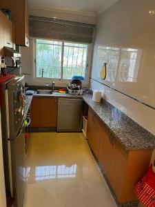 アシラにあるMarina golf ASSILAH vue verteのシンクと冷蔵庫付きのキッチン