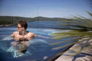 um homem numa piscina com uma palmeira em Hotel Riviera em Moss