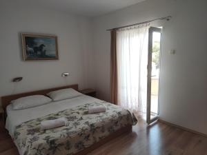 una camera con un letto e una grande finestra di Apartments Dijana a Krk