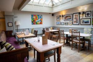 un restaurante con mesas y sillas en una habitación en Castle and Ball by Greene King Inns, en Marlborough