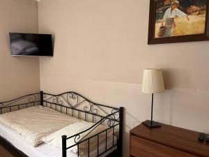 1 dormitorio con 1 cama y una foto en la pared en Hostel Sadowianka, en Ostrów Wielkopolski