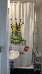 a bathroom with a shower curtain with a crown on it at Appartment First in Duisburg