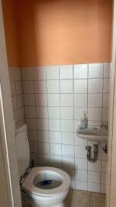 a bathroom with a toilet and a sink at Appartment First in Duisburg