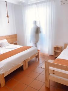a bedroom with two beds and a person standing in the window at Quinta de São Pedro de Tomar in Tomar