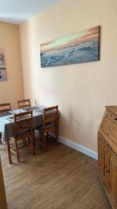 a dining room with a table and chairs and a painting at Appartment First in Duisburg