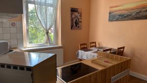 eine Küche mit einer Theke, einem Tisch und einem Fenster in der Unterkunft Appartment First in Duisburg