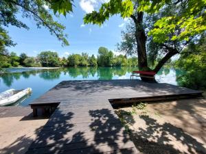 a bench sitting on a dock next to a lake at Apartman "MEDENI" in Bihać