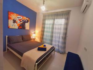 1 dormitorio con cama y pared azul en Perseas House, en Argos