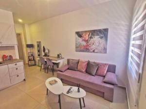 uma sala de estar com um sofá roxo e mesas em Perseas House em Árgos