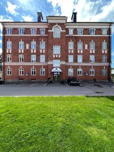 un gran edificio de ladrillo rojo con un coche aparcado delante en Carlstad Sport Hostel, en Karlstad