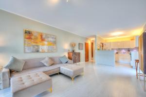 ein Wohnzimmer mit einem Sofa und einer Küche in der Unterkunft Emotion Lake View - Happy Rentals in Capolago