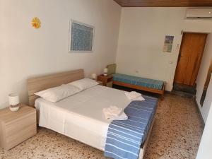 - une chambre avec un lit blanc et un banc bleu dans l'établissement Casa Vacanze A Due Passi dal Mare, à Portopalo di Capo Passero