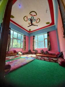 a large room with a large green floor with a ceiling at POP HOME Rozia Homestay in Thanna Mandi