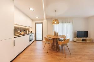 cocina y comedor con mesa y sillas en Bravissimo Devesa, 3 bedrooms and near the parc, en Girona