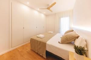 a white bedroom with a bed and a ceiling fan at Bravissimo Devesa, 3 bedrooms and near the parc in Girona