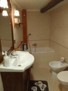 uma casa de banho com um lavatório, um WC e uma banheira em HomeDavidAlvito em Alvito