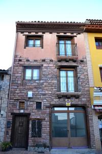 un edificio de ladrillo con muchas ventanas. en Apartamentos La Sierra, en Villalba de la Sierra