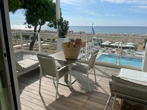 un tavolo e sedie su un balcone con vista sulla spiaggia di Hotel Ril a Lido di Jesolo