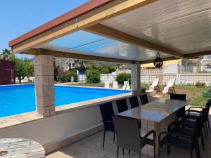 un patio con mesa y sillas y una piscina en Villa Fortuna, en Alcanar