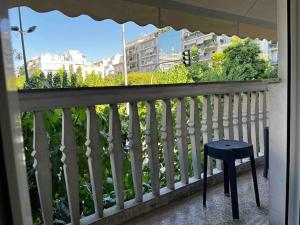 un tabouret sur un balcon avec une clôture blanche dans l'établissement Deseo Apartments, à Athènes