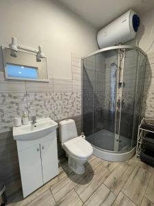 a bathroom with a toilet and a shower and a sink at Apartamenti Starp Krastiem 2 in Liepāja