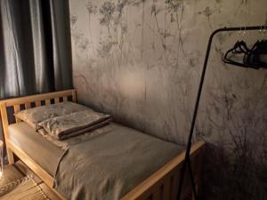 a small bed in a room with a wall at Mazury Holiday Cottage in Piecki