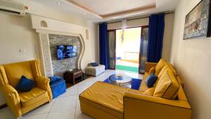 sala de estar con 2 sillas amarillas y sofá en Lux Suites Shanzu Seabreeze Apartments, en Shanzu