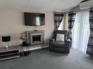 a living room with a chair and a fireplace at Meridian Lodge in Great Billing