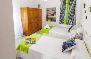 two beds in a room with green sheets at A Casa De Lucha in Meis