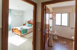 - une chambre avec un lit, un lavabo et un miroir dans l'établissement A Casa De Lucha, à Meis