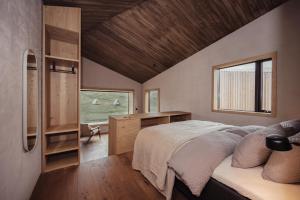 a bedroom with a bed and a desk and a window at Highland Base Kerlingarfjöll in Kerlingarfjoll