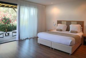 - une chambre avec un lit et une porte coulissante en verre dans l'établissement Hotel Restaurant Mariosa, à Porto-Vecchio