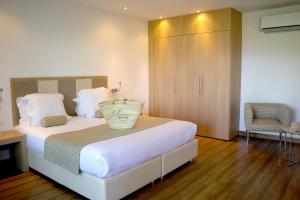 - une chambre avec un lit, une armoire et une chaise dans l'établissement Hotel Restaurant Mariosa, à Porto-Vecchio
