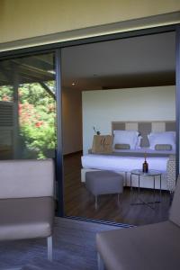a bedroom with a large bed and a couch at Hotel Restaurant Mariosa in Porto-Vecchio