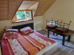 1 dormitorio con cama y mesa en el ático en Agroturystyka Kajaki Sauna Pierogi, en Bakałarzewo