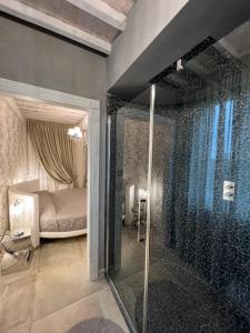 a bathroom with a glass shower and a bedroom at L’ Aia del Principe in Montepulciano
