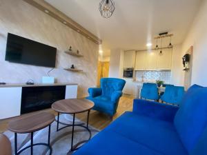 Nirvana 02 في زلاتيبور: غرفة معيشة مع كراسي زرقاء وتلفزيون