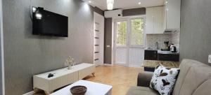 a living room with a couch and a tv on the wall at NANO'S APARTAMENt-1 in Kutaisi