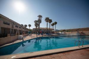 a large swimming pool in a resort with palm trees at Destino De Sol De Los Alcazares in Los Alcázares