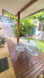 un patio con mesa, sillas y hamaca en Apartamento Ambar, en Búzios