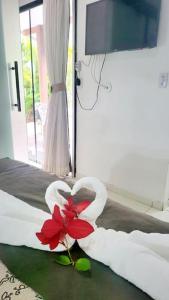 un cisne hecho de una flor en una cama en Apartamento Ambar, en Búzios