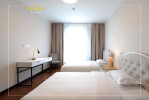 - une chambre blanche avec un lit et un bureau dans l'établissement Morning Star Residences Ulaanbaatar, à Oulan-Bator