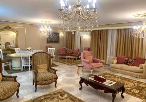 Luxury Apartment 2 Nasr City- City stars في القاهرة: غرفة معيشة فيها ثريا وطاولة وكراسي