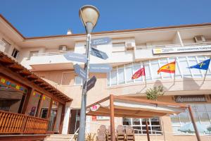 ロス・アルカサレスにあるDestino De Sol De Los Alcazaresの旗印入りの建物前の看板