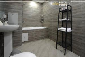 La salle de bains est pourvue d'un lavabo, de toilettes et d'une douche. dans l'établissement Morning Star Residences Ulaanbaatar, à Oulan-Bator